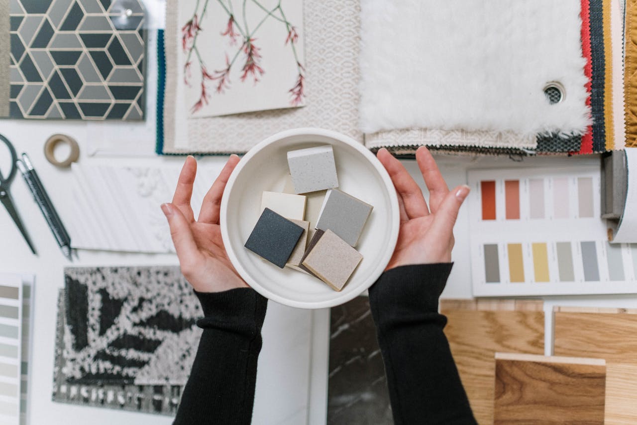 trusted-partner Overhead view of a person holding samples amidst an array of interior design materials and color swatches.
